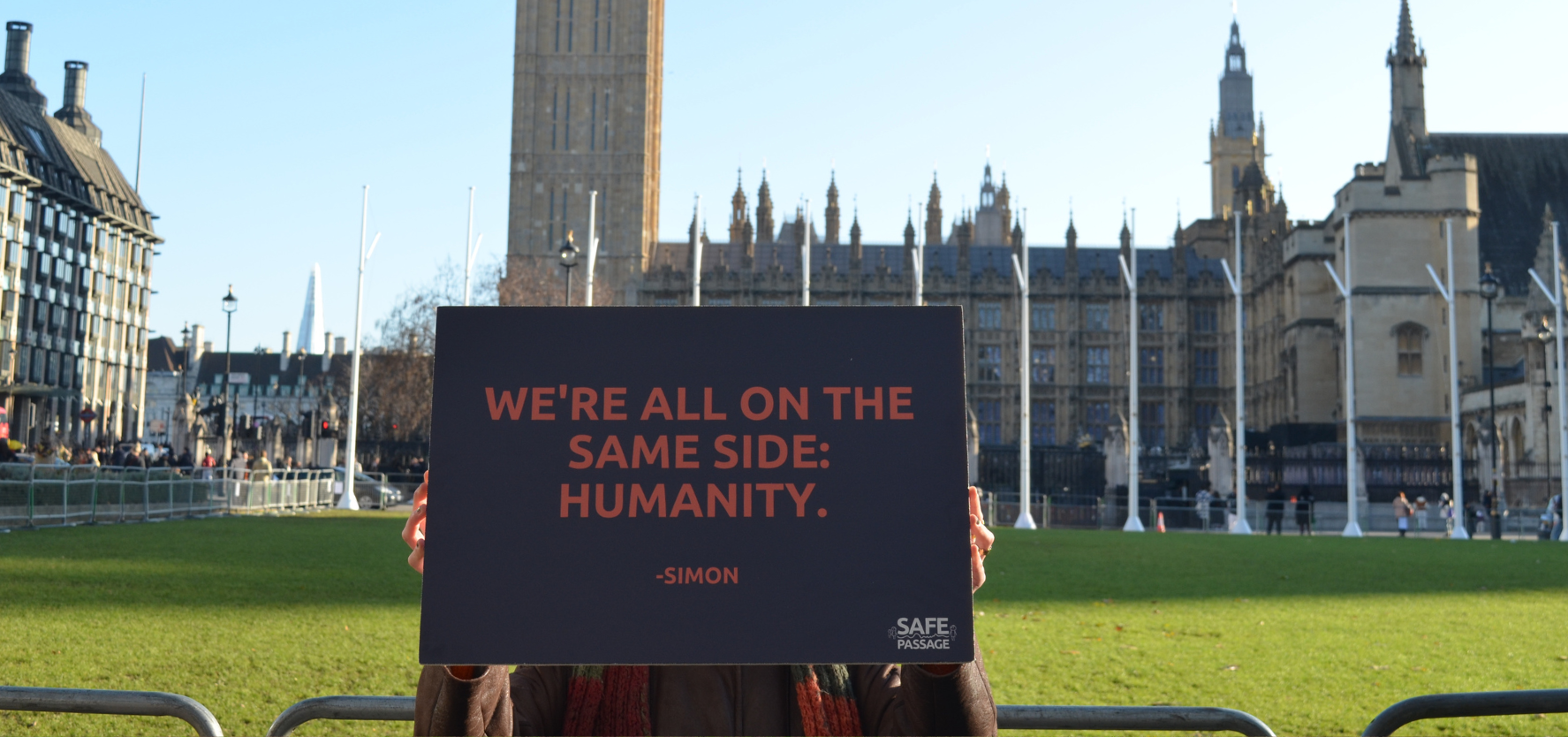 A person holding up a sign in front of Westminster