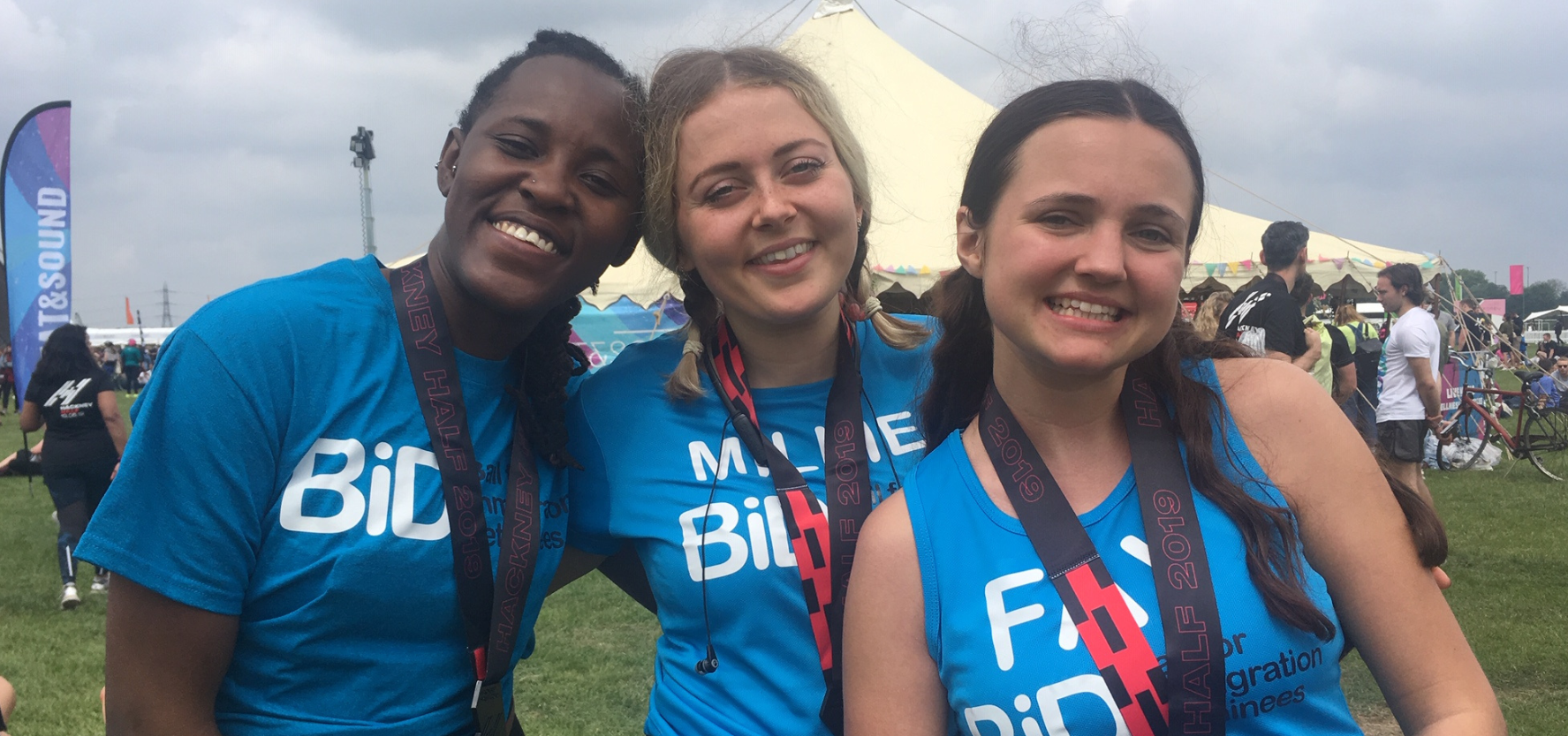 The BID team are photographed on a fundraising walk. They are wearing blue T-shirts and cheering