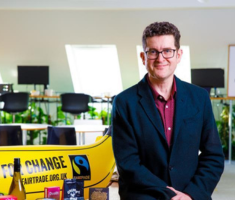 A photo of Michael Gidney in front of the Fairtrade logo