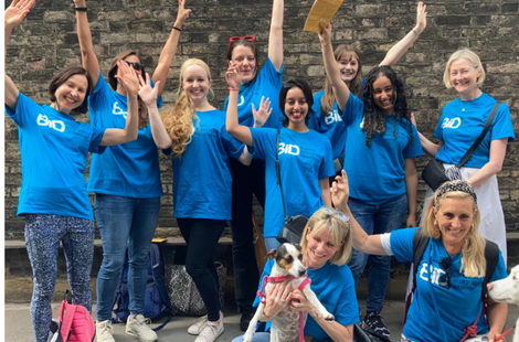 The BID team are photographed on a fundraising walk. They are wearing blue T-shirts and cheering